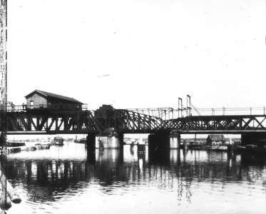 886051 Gezicht op de sppoorbrug (rolbasculebrug) over de Delfshavensche Schie bij Rotterdam.